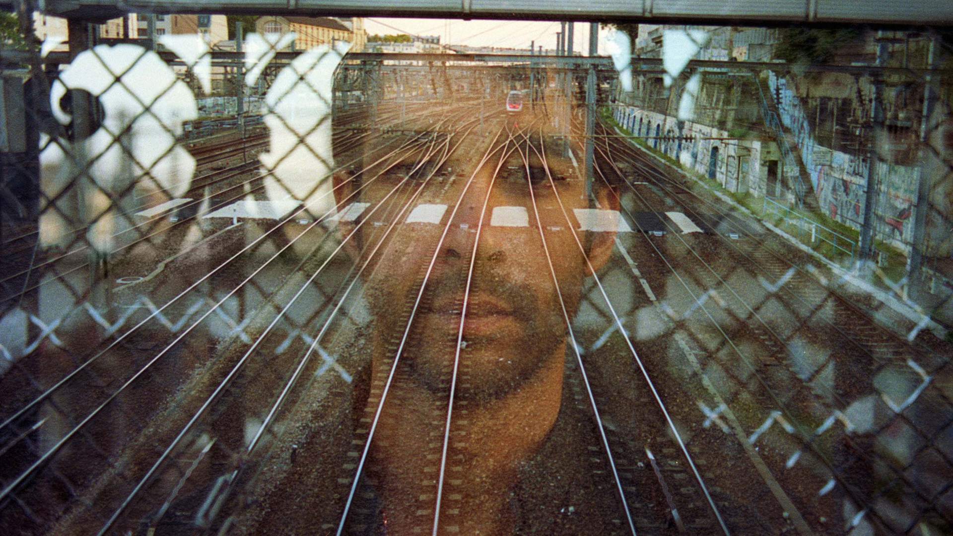 Alex Stuart in double exposure over Paris railway tracks, photo by Arthur Wollenweber