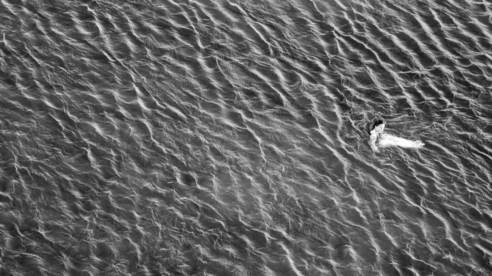 Refuge album artwork by Alex Stuart, a swimmer alone in shimmering water