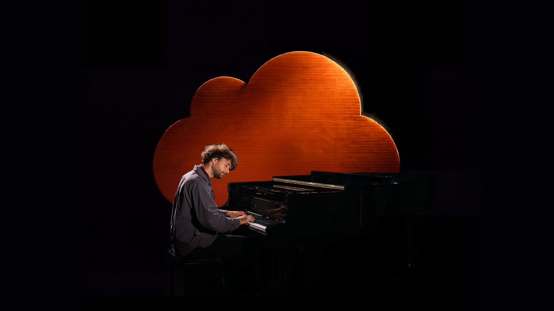 Makera at the piano in front of the amber cloud, From The Cloud EP artwork