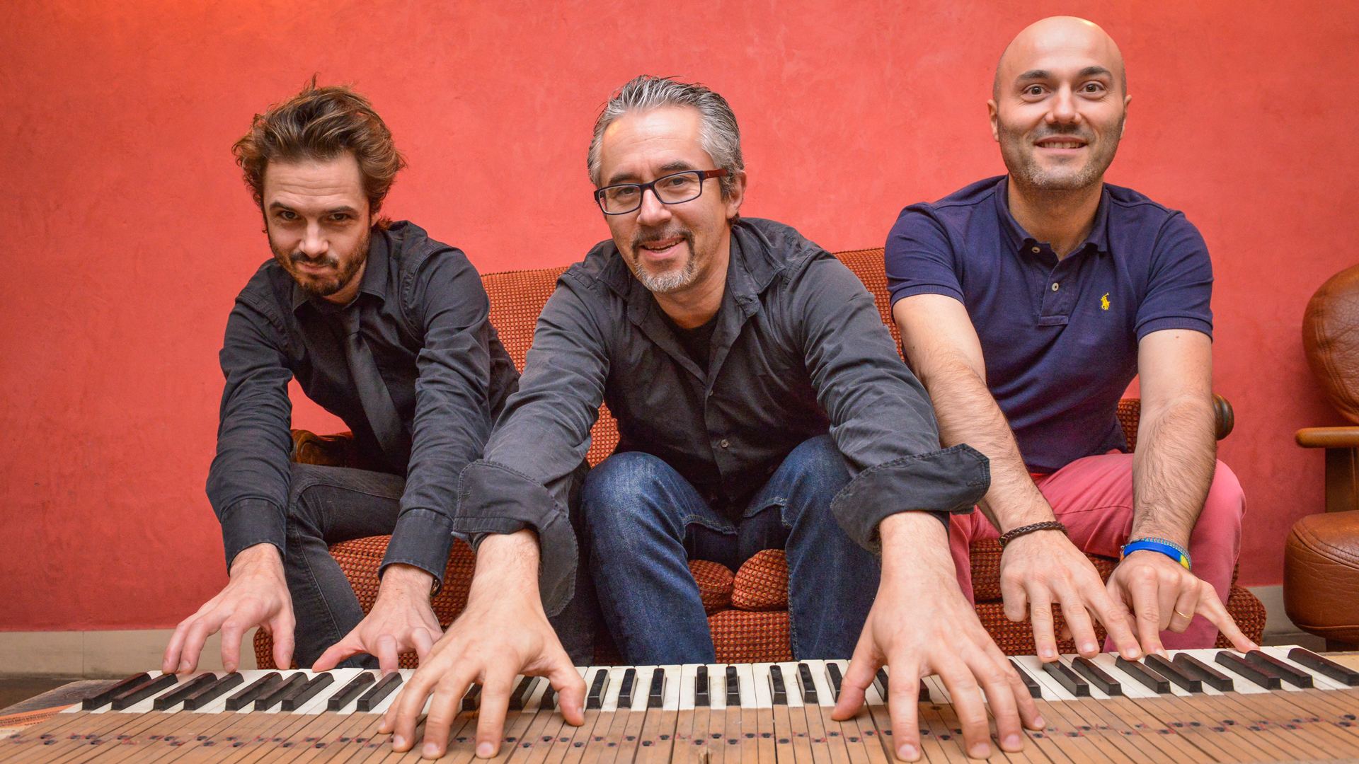 Manuel Rocheman Trio at the keyboard of an open piano